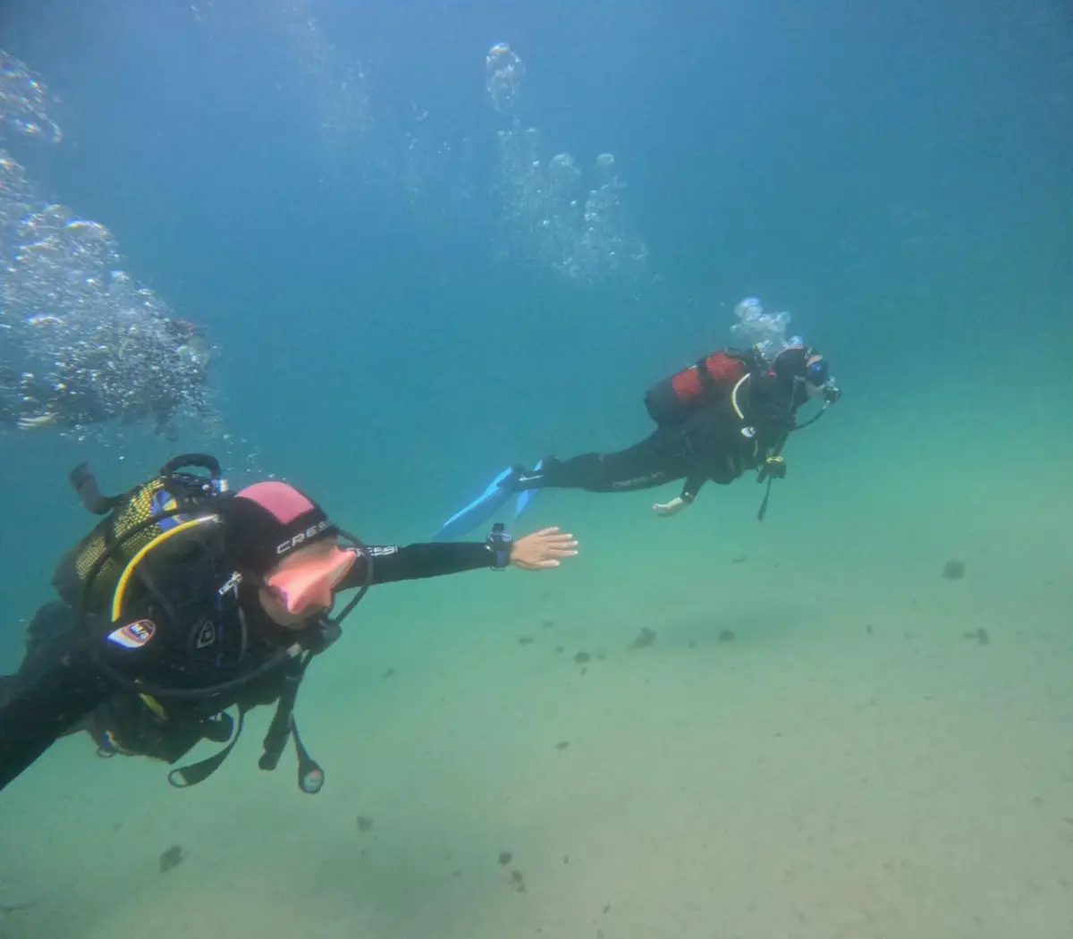 Divers exploring the sandy bottom